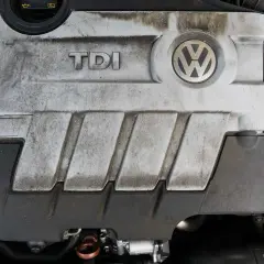 Pokrywa silnika TDI z logo VW. Silnik 1.9 TDI 105 KM, lekko zabrudzony, ale wciąż gotowy do pracy.