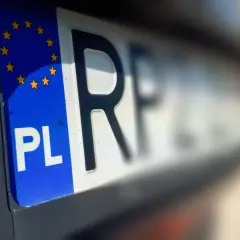 Zbliżenie na polską tablicę rejestracyjną z symbolem Unii Europejskiej. Litery "PL" i fragment numeru wskazują na bsi rejestracja.