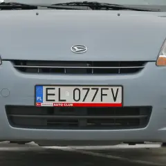 Przód szarego samochodu z widocznym logo Daihatsu i tablicą rejestracyjną EL 077FV.