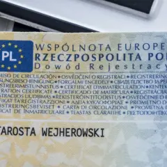 Dowód rejestracyjny pojazdu z pieczęcią Starosty Wejherowskiego. Dokument zawiera nazwy w wielu językach.