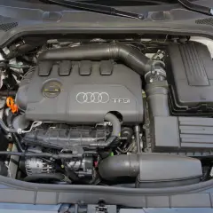 Widok komory silnika z widocznym silnikiem 2.0 TFSI Audi, zbiornikiem płynu chłodniczego i filtrem powietrza.