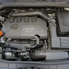 Silnik TFSI w Audi 8P. Widoczne elementy układu dolotowego, zbiornik płynu chłodniczego i alternator.