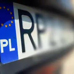 Zbliżenie na polską tablicę rejestracyjną z symbolem Unii Europejskiej. Litery "PL" i fragment numeru wskazują na cg rejestracja.