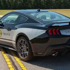 Czarny Ford Mustang w barwach policji "State Trooper" z napisem na boku i tyle.