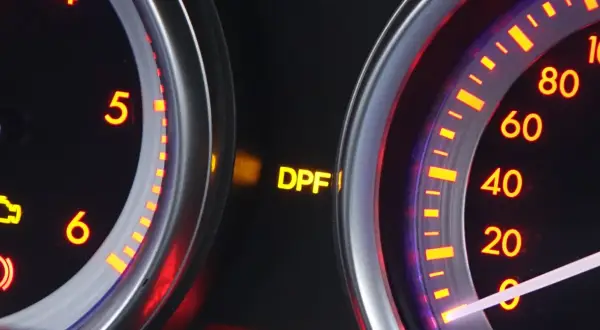 Żółta kontrolka DPF świeci się na desce rozdzielczej, sygnalizując problem z filtrem cząstek stałych.