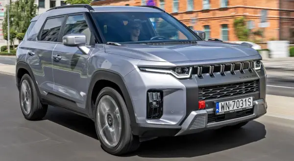 Srebrny SsangYong Torres jedzie ulicą.
