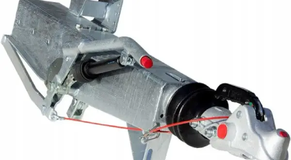 Metalowy hamulec najazdowy do przyczepy z mechanizmem i zaczepem kulowym.