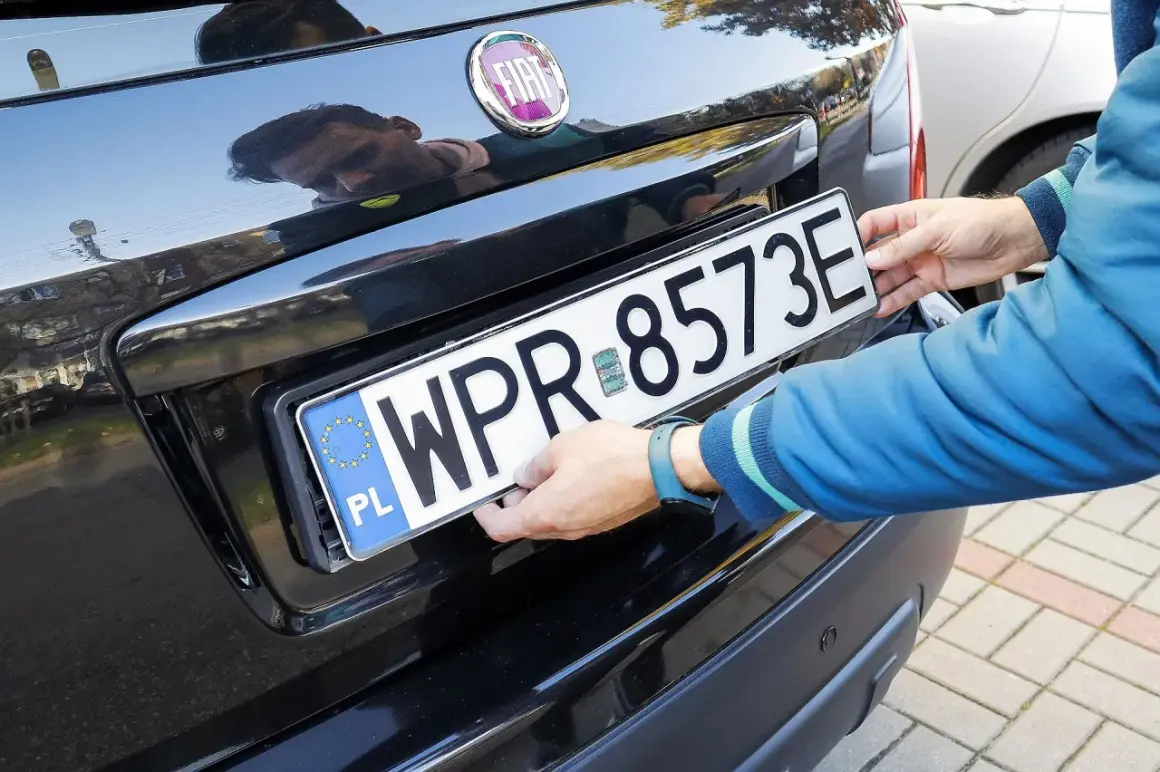 Ręce montują tablicę rejestracyjną WPR 8573E. To może być duplikat tablicy rejestracyjnej, gdy oryginał zaginął.