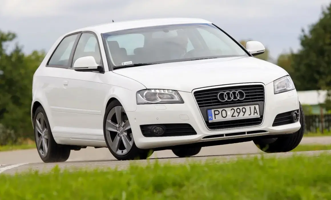 Białe Audi A3 8P 1.6 MPI na zakręcie. Kierowca w środku. Opinie o tym modelu są różne, ale wygląd zachwyca.