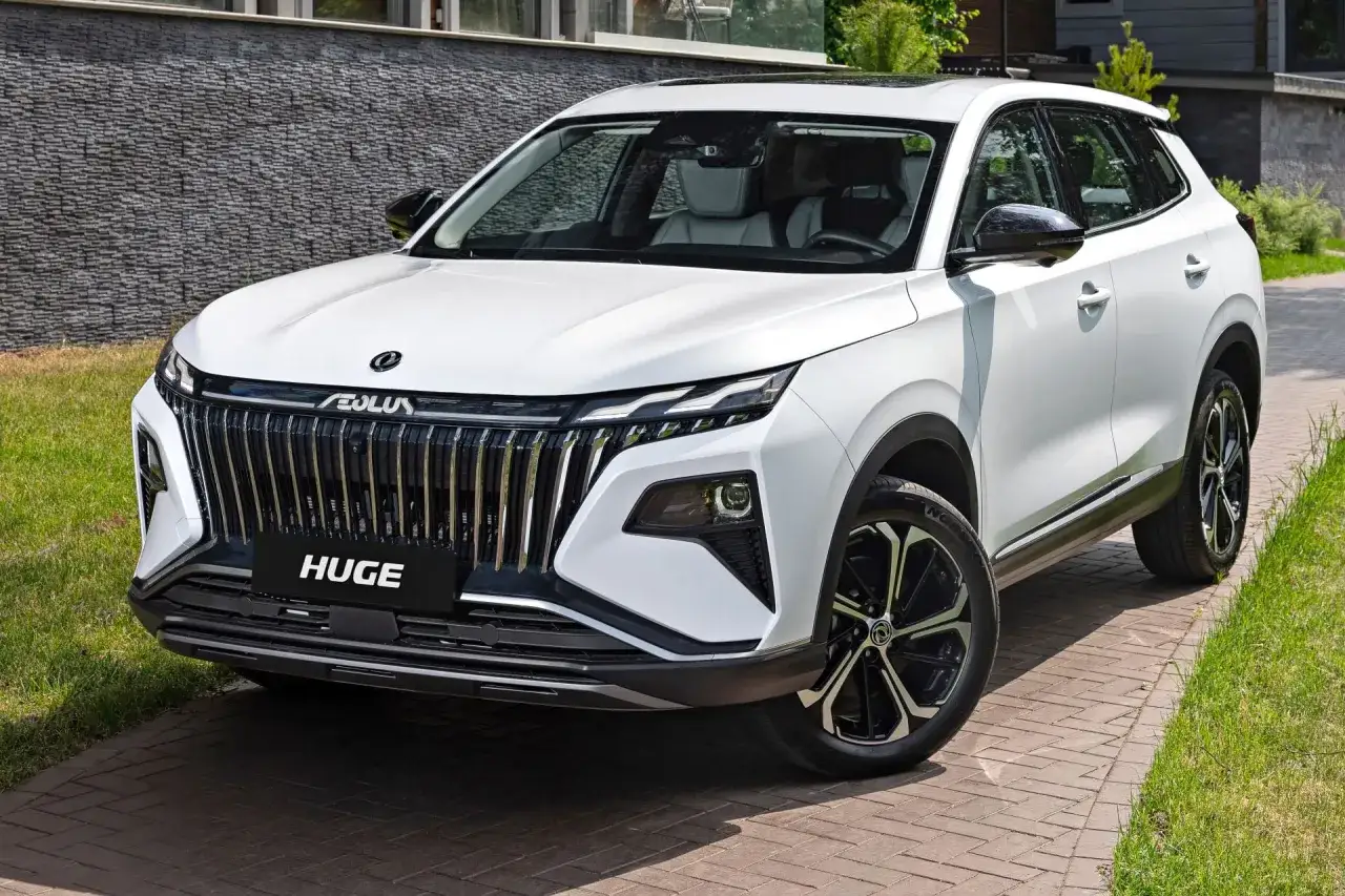 Biały chiński SUV z imponującym chromowanym grillem i napisem