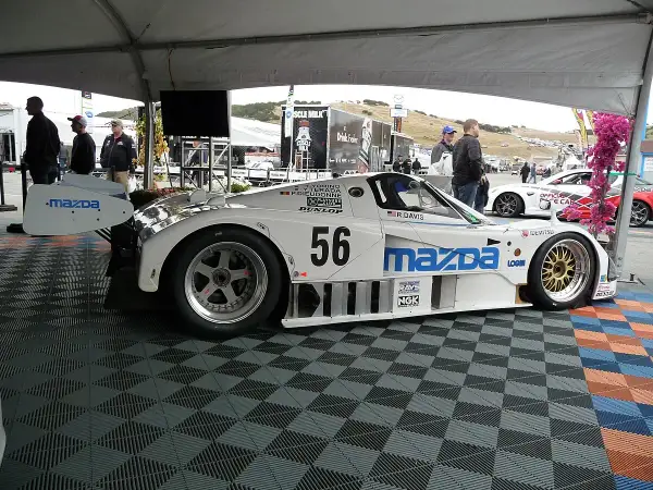Legenda: Biały samochód wyścigowy Mazda 787B z numerem 56, gotowy do startu.
