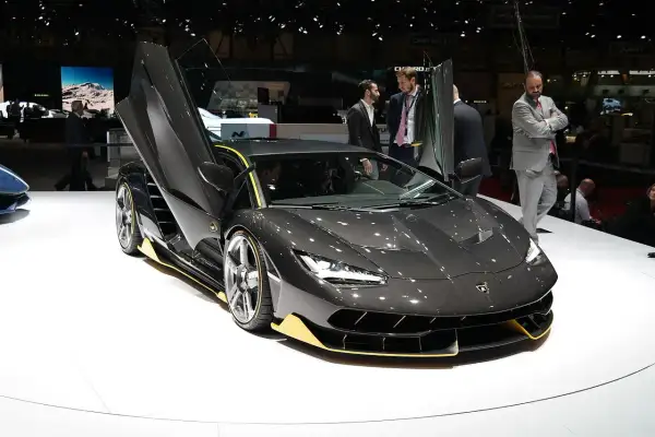 Ciemnoszary Lamborghini z otwartymi drzwiami, z żółtymi akcentami. Zastanawiasz się, ile kosztuje Lamborghini?