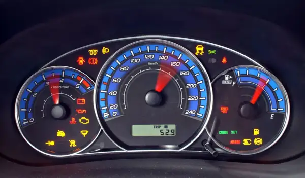 Deska rozdzielcza Ford Kuga z wieloma kontrolkami, w tym ABS, poduszka powietrzna i ostrzeżenie o niskim poziomie paliwa.