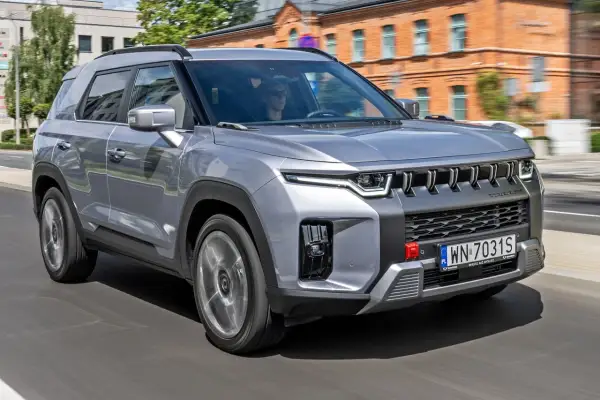 Srebrny SsangYong Torres jedzie ulicą.