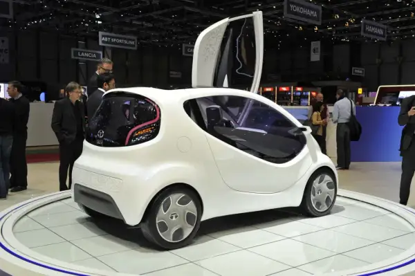 Białe, futurystyczne auto, które mogłoby być najtańszym autem na świecie, prezentowane na wystawie.