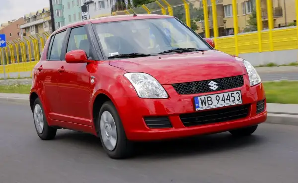 Czerwony Suzuki Swift 2008 na drodze, z widocznymi tablicami rejestracyjnymi WB 94453.